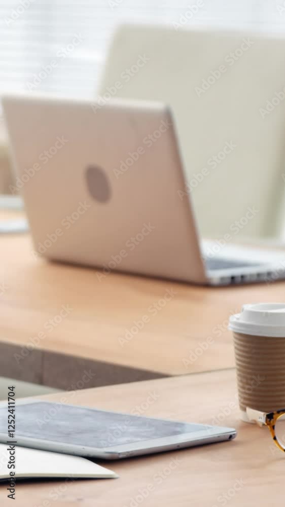 Spectacle, disposable coffee cup, laptop, computer and digital tablet on desk