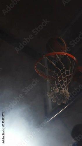 Sportsman dunking basketball in hoop