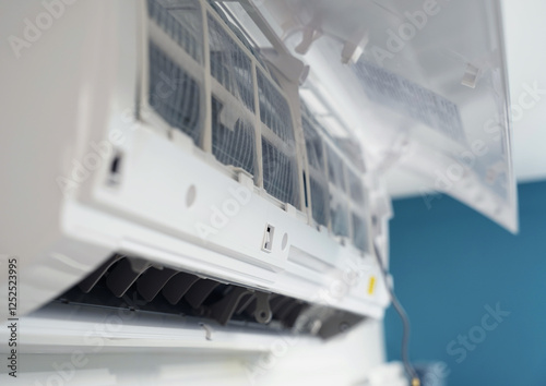 The worker cleans and repairs the air conditioner to ensure it operates properly photo