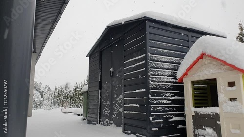 Toolshed in the winter while snowing photo