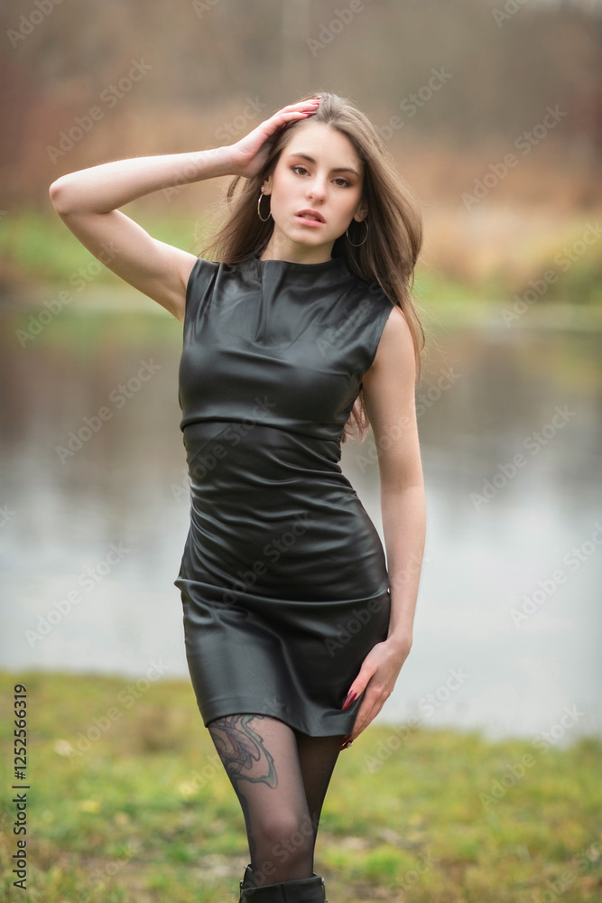 Portrait of a young beautiful brown-eyed long-haired girl in a black dress in nature. Portrait of a young beautiful brown-eyed long-haired girl in a black dress in nature.