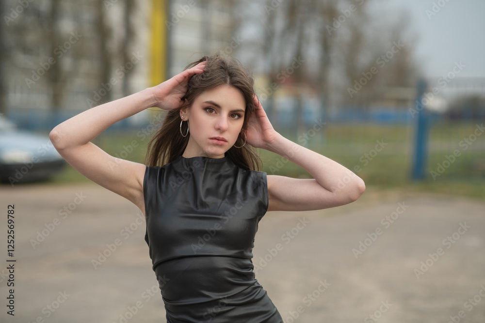 Portrait of a young beautiful brown-eyed long-haired girl in a black dress in nature. Portrait of a young beautiful brown-eyed long-haired girl in a black dress in nature.