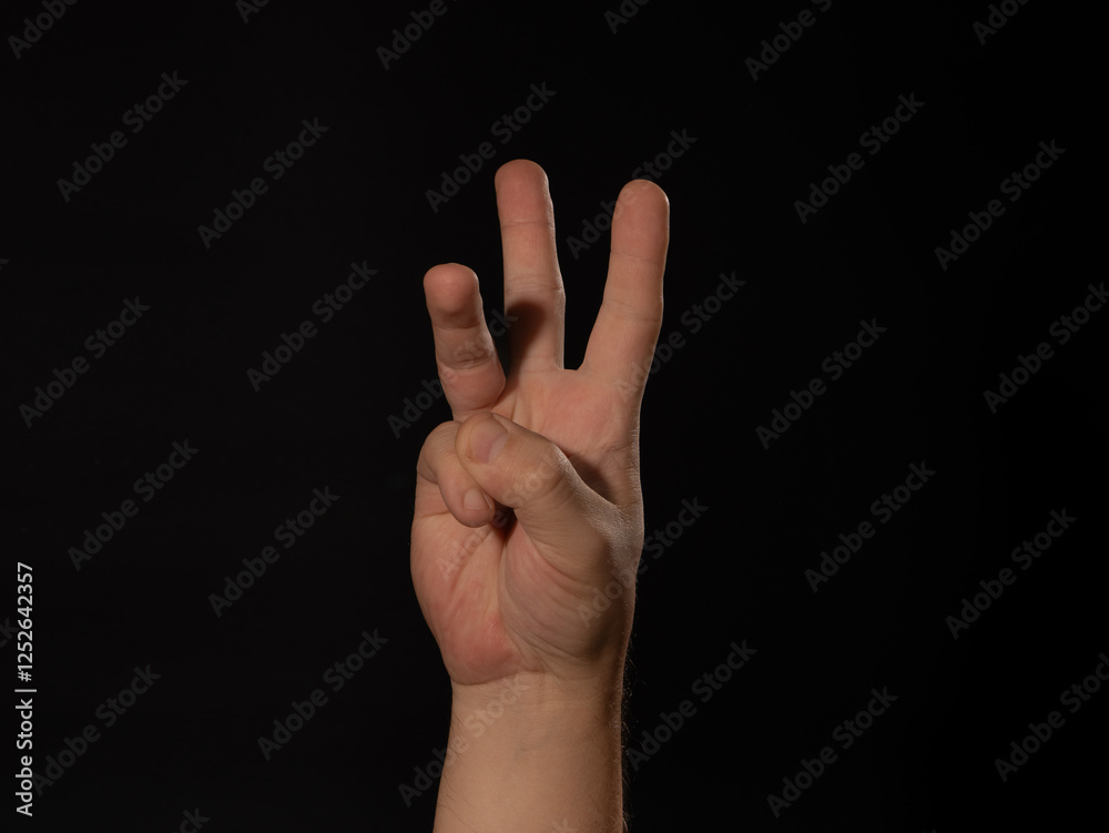 A hand is raised with three fingers extended A hand is raised with three fingers extended