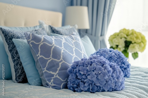 Blue hydrangea bouquets arranged on a bed with navy blue pillows in a serene ...