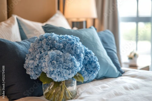 Blue hydrangea bouquets arranged on a bed with navy blue pillows in a serene ...