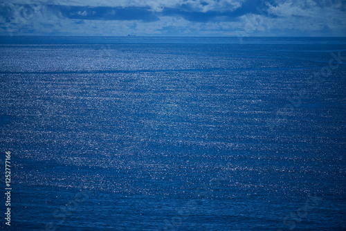 青く輝く海面と遠くの船の風景 photo