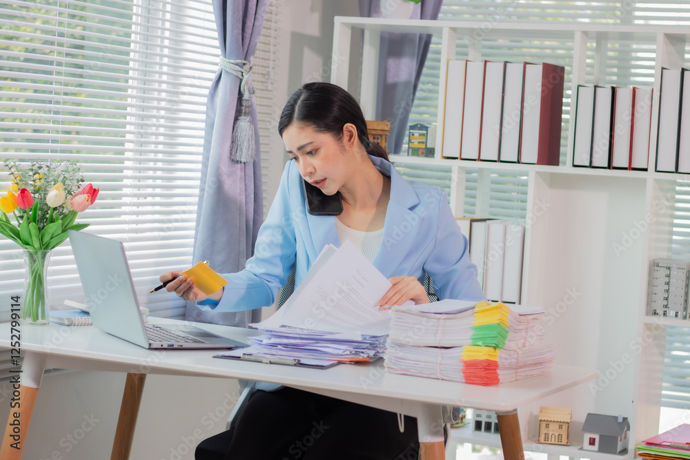 Businesswoman working in the office and using a smartphone to talk with customers
