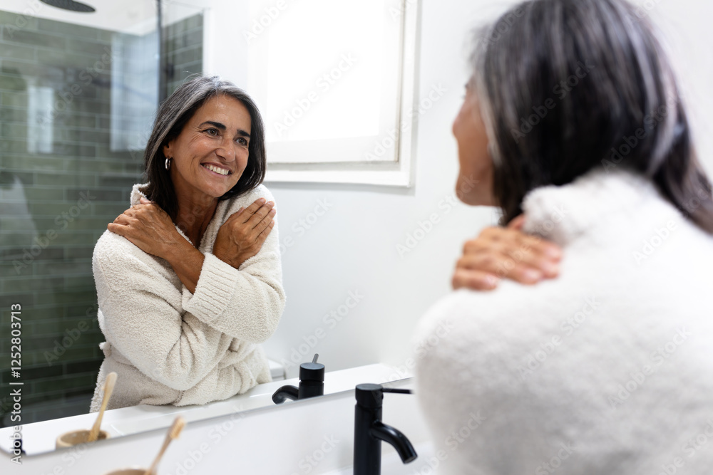 Mature woman embracing herself in front of mirror. Female expressing self love. Mature woman embracing herself in front of mirror. Female expressing self love.