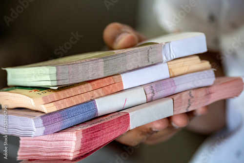 Karachi, Pakistan - April 23, 2024: Pakistani banknote bundles stacked on isolated background photo