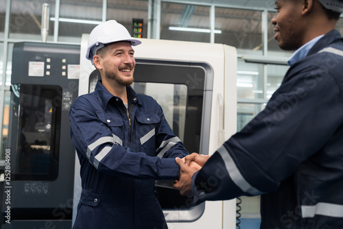 Happy smiling two male engineer handshake together in workshop room of building. Successful, Unity and teamwork, Finished and completed work concept