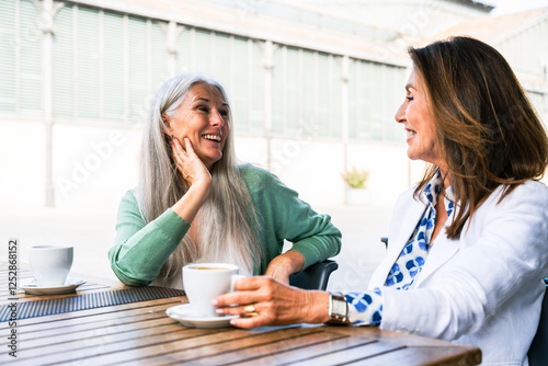 Beautiful senior women bonding outdoors in the city - Attractive cheerful mature female friends having fun, shopping and bonding, concepts about elderly lifestyle