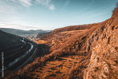 Steilhang mit Blick ins Tal, Fluss und Straße unter blauem Himmel photo