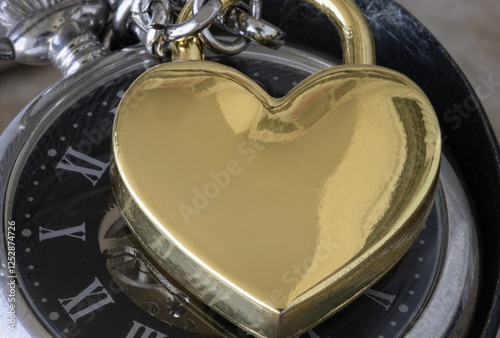 Obraz na płótnie Close-up of Golden heart shaped love padlock on A retro pocket watch. Love can endure beyond the limitations of time, Concept of Love that transcends time, Valentine's day, use it as your Copy space. w salonie