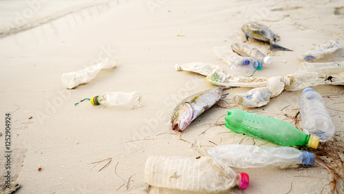 Dead fish on a beach littered with plastic waste, sea life killed by ocean pollution, marine debris 