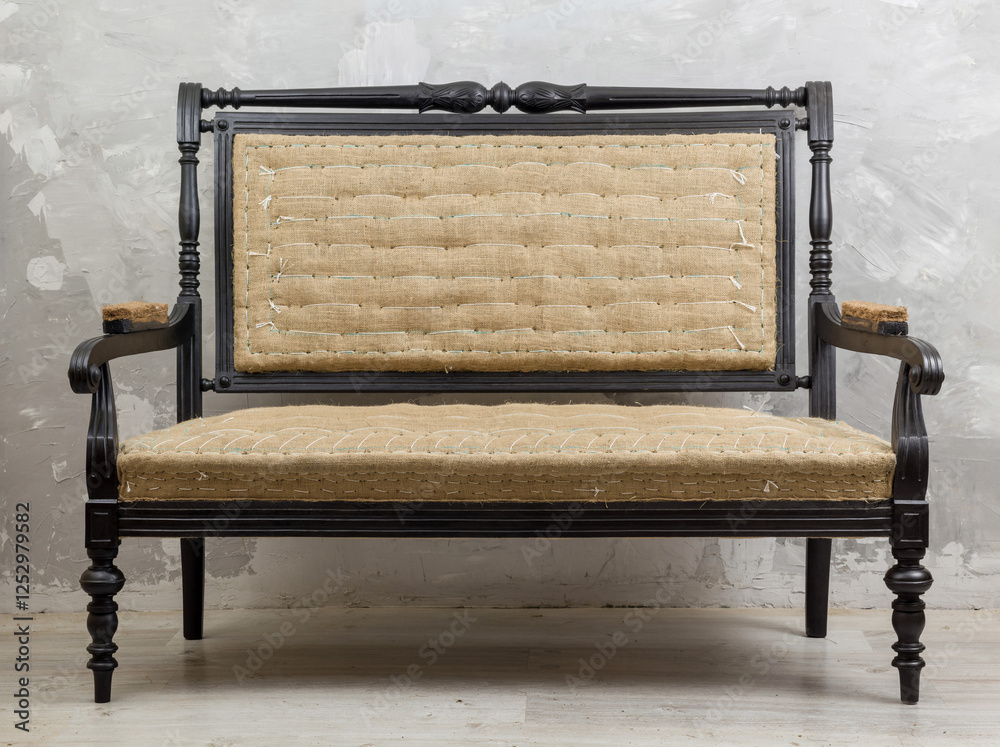 Antique or vintage settee with a dark wood frame and light woven upholstery.