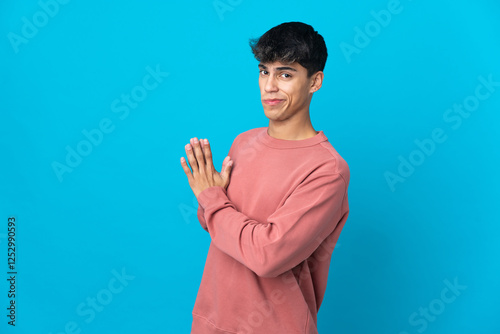 Young man over isolated blue background scheming something