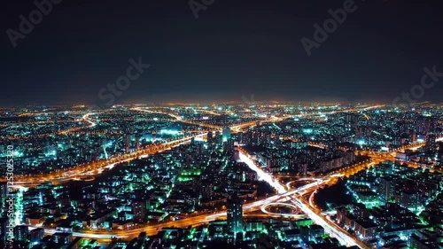 Wallpaper Mural Aerial view of a vibrant city at night with glowing blue and orange lights. Highways form intricate patterns, connecting urban structures. Concept of urbanization and night life Torontodigital.ca