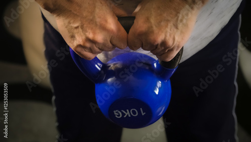 Obraz na płótnie Hands gripping blue kettlebell for workout preparation w salonie