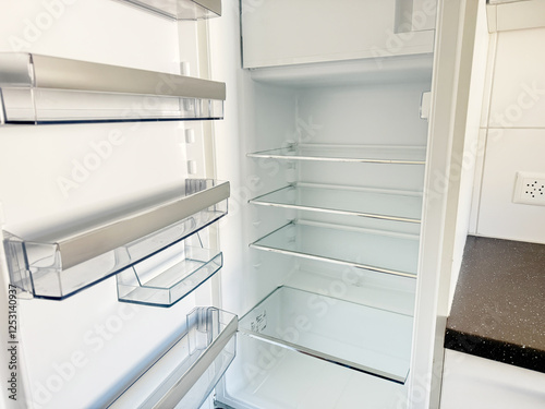 Empty Refrigerator Shelves. High quality photoA clean and spacious refrigerator with empty glass shelves and transparent door compartments, ready to be stocked with fresh groceries. The minimalist and photo