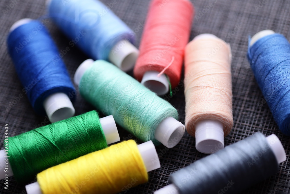 A collection of thread spools arranged neatly on a table, suitable for crafting, sewing, or DIY projects. A collection of thread spools arranged neatly on a table, suitable for crafting, sewing, or DIY projects.