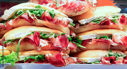 sandwiches stuffed with ham and fresh rocket on sale in the bar display photo