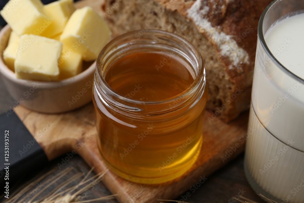 Sweet honey, butter, bread and milk on wooden table, closeup Sweet honey, butter, bread and milk on wooden table, closeup