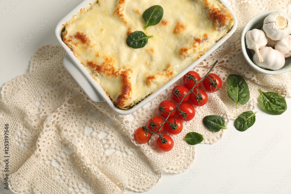 Delicious spinach lasagna in baking dish and ingredients on white table, flat lay Delicious spinach lasagna in baking dish and ingredients on white table, flat lay