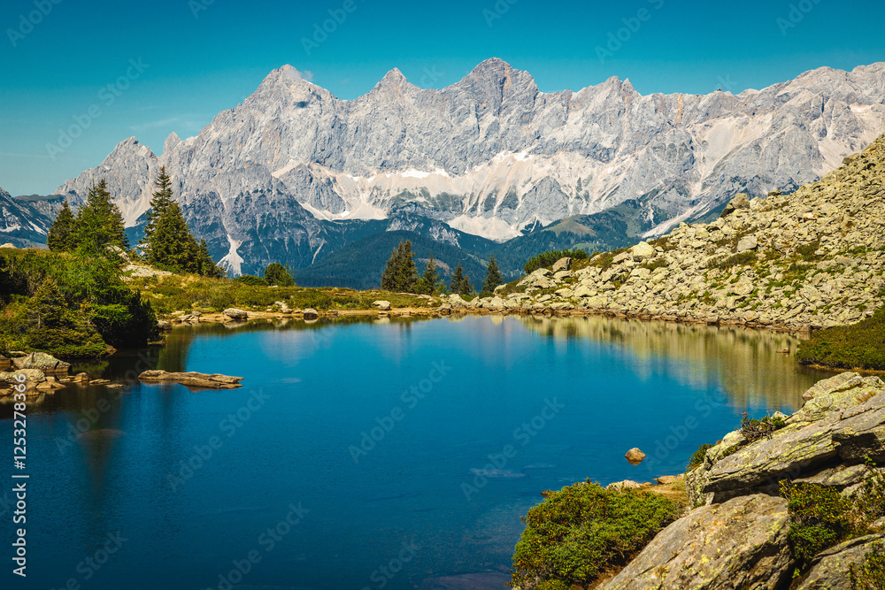 Clean alpine lake and high mountain ridges in Austria