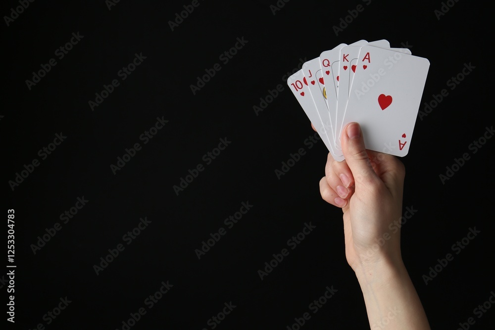 Obraz premium Woman with playing cards against black background, closeup