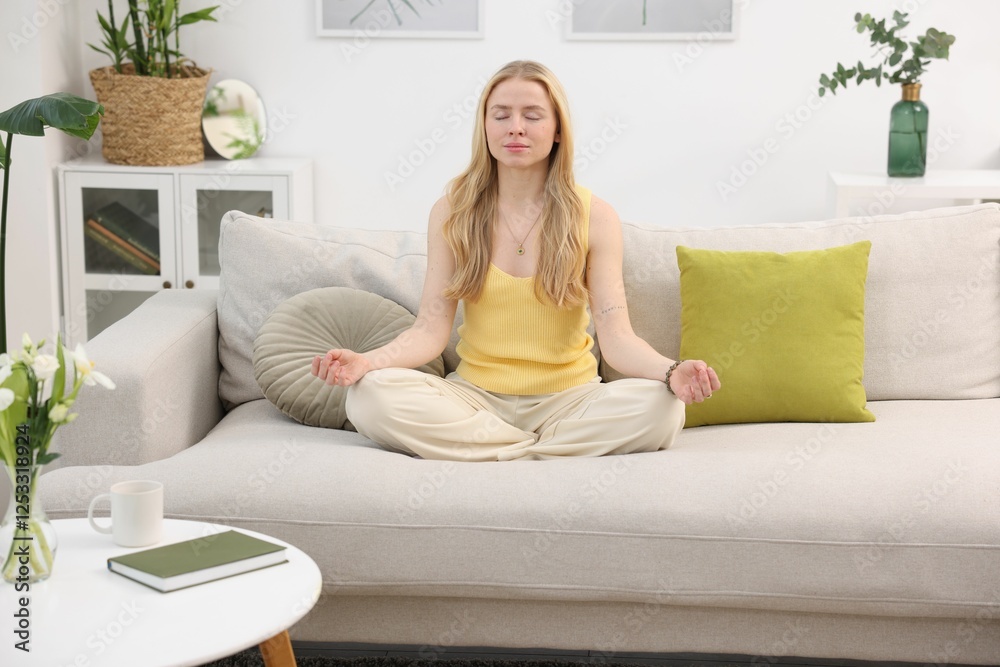Feng shui. Young woman meditating on couch at home Feng shui. Young woman meditating on couch at home