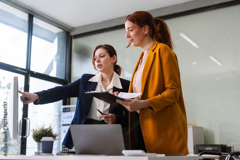 Diverse professionals collaborate on project analysis with financial graphs. Diverse professionals collaborate on project analysis with financial graphs.