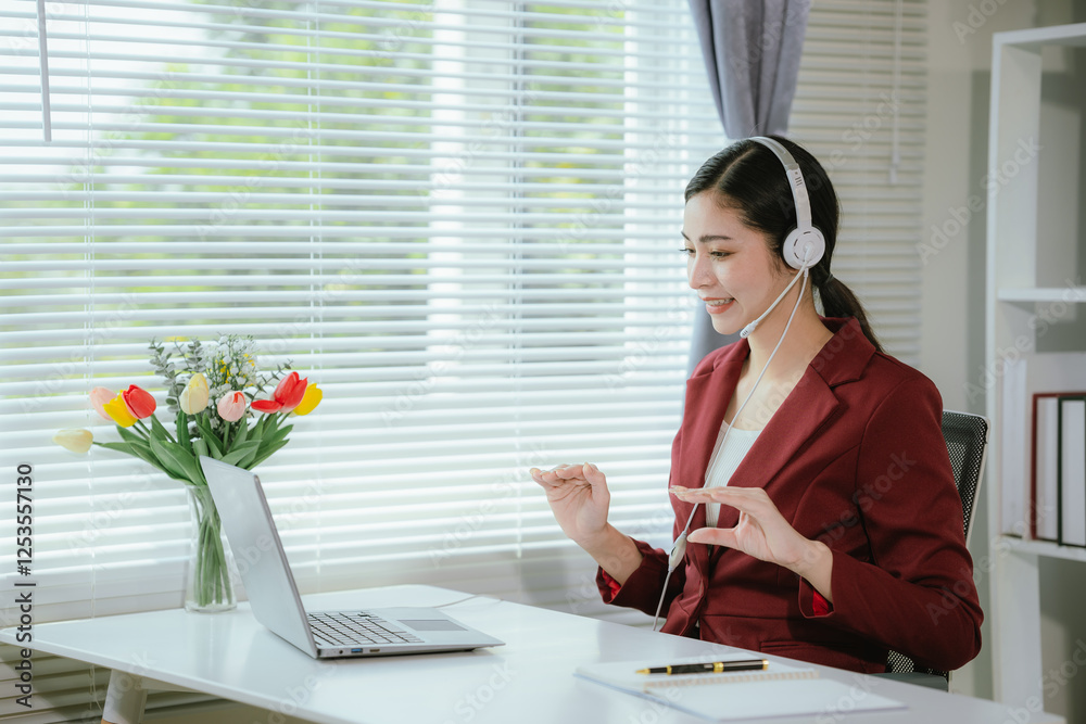 Professional businesswoman in office wearing headset to provide support and assistance to customers. She smiles while communicating with customers, presenting corporate services. Professional businesswoman in office wearing headset to provide support and assistance to customers. She smiles while communicating with customers, presenting corporate services.