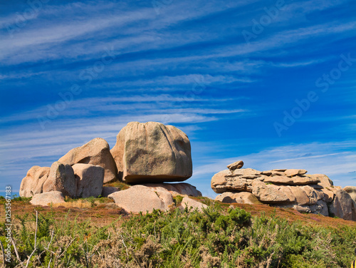 Rock formations on the famous Pink Granite Coast near Ploumanac'h in Perros-Guirec, Lannion, Brittany in Northern France. Taken on a sunny day in summer, with a blue sky and light cloud.