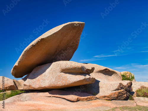 Rock formations on the famous Pink Granite Coast near Ploumanac'h in Perros-Guirec, Lannion, Brittany in Northern France. Taken on a sunny day in summer, with a blue sky and light cloud.