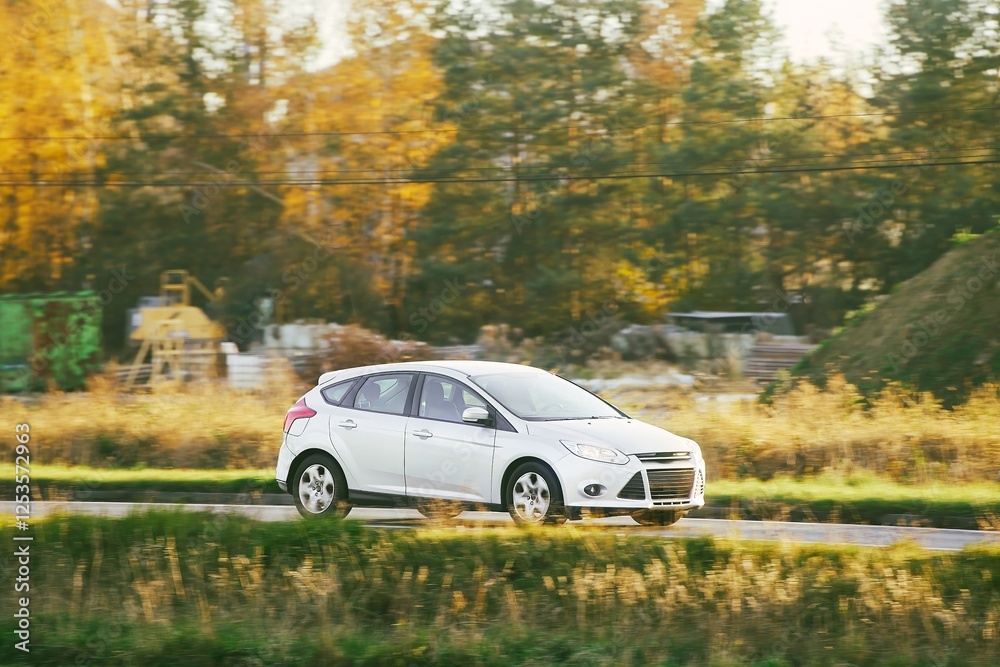 Fototapeta premium White hybrid car driving on rural road