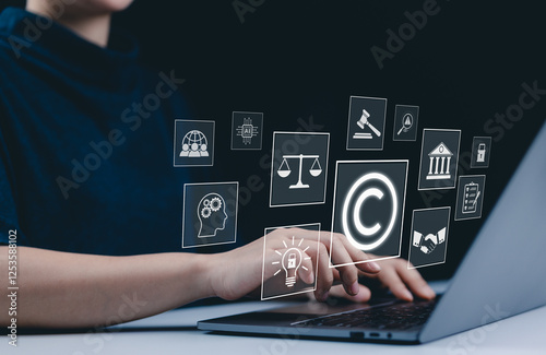 Copyright and intellectual property protection concept. A person use laptop with icons copyright, intellectual property, legal balance scales, patents, technology law, digital rights, and protection. photo