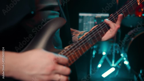 Bearded guy in a cap plays at a rock concert with guitar the soloist sings a song for his fans. Guitarist play his notes.