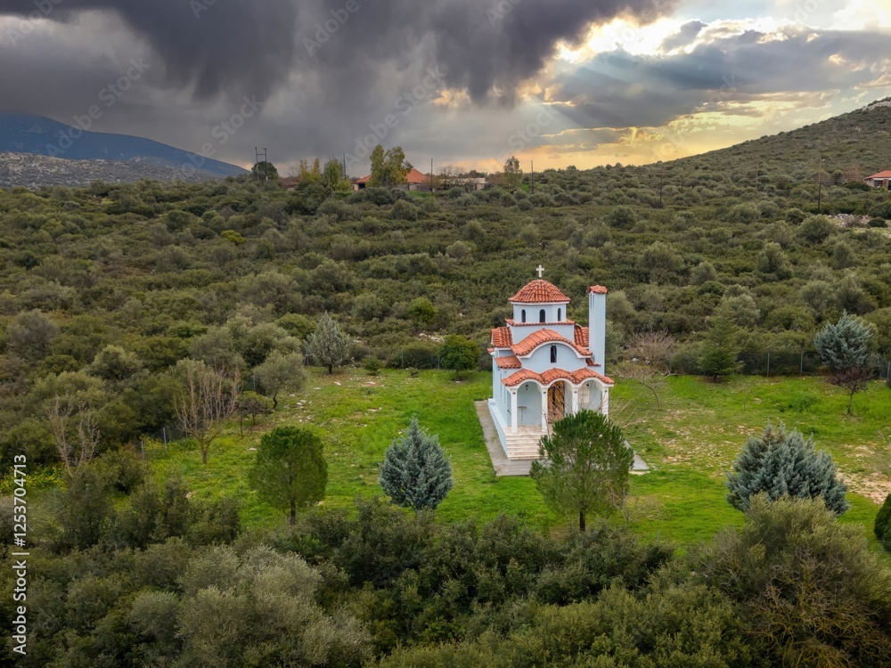 Obraz premium Blue Greek Church Amidst Lush Greenery.