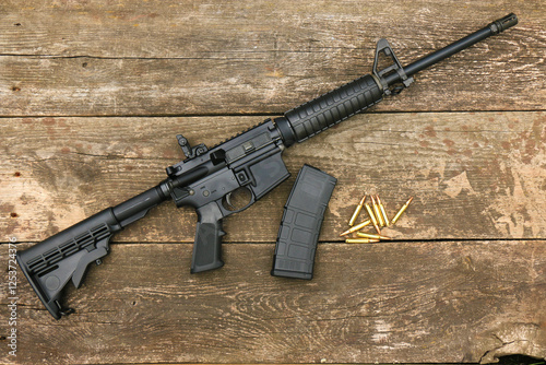 Foto AR15 assault rifle with an adjustable stock, box magazine and 5,56mm ammunition on the background of old boards