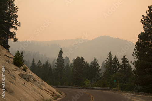 Obraz na płótnie Janesville Grade in Lassen County, California, covered in thick smoke from the 2021 Dixie Fire, with hazy forested mountains in the background
