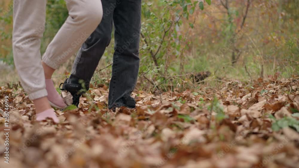 Leg view of two individuals walking through dry autumn leaves in an outdoor setting, capturing connection with nature, movement, and the soothing crunch of leaves underfoot Leg view of two individuals walking through dry autumn leaves in an outdoor setting, capturing connection with nature, movement, and the soothing crunch of leaves underfoot