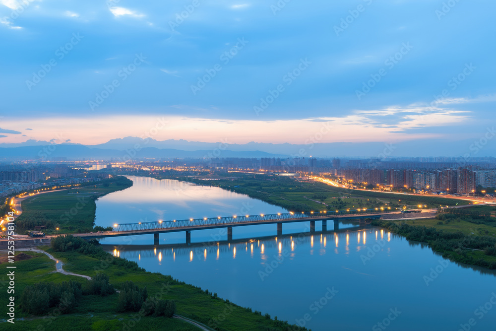 Evening view of a river with glowing lights and a distant city skyline at twilight Evening view of a river with glowing lights and a distant city skyline at twilight