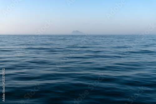 Obraz na płótnie island in the fog on the sea at dawn w salonie