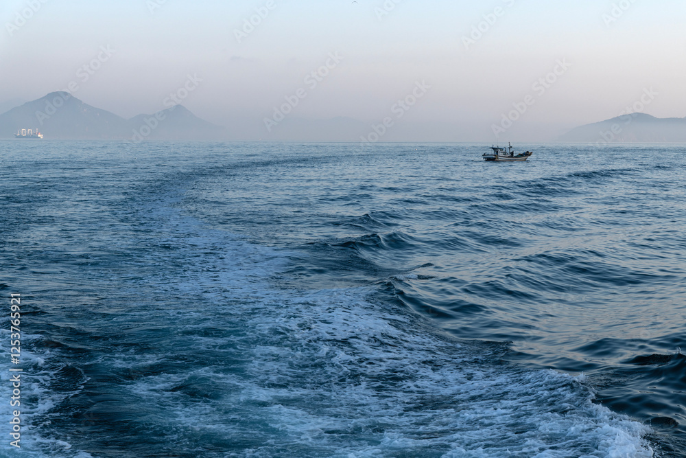 Obraz premium fishing boat with fog on the sea at dawn