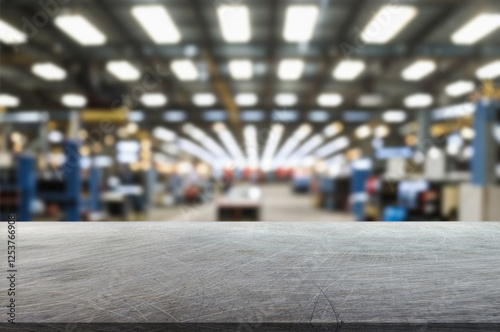 blurred background of factory and empty steel tabletop in foreground. Business presentation