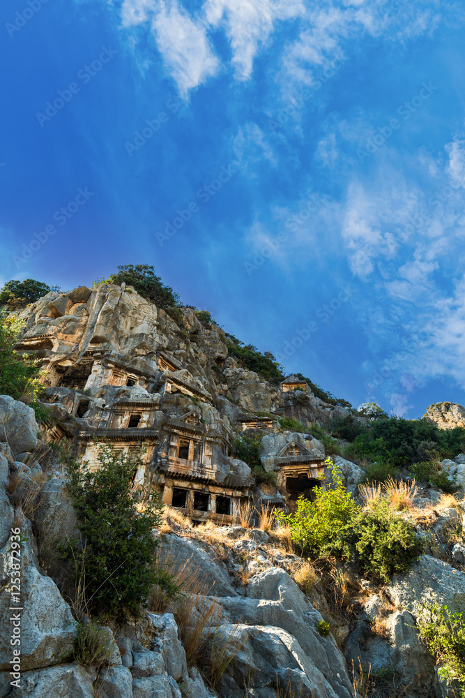 Naklejka premium Myra archaeological site with rock tombs in Demre, Turkey. The Ancient City of Myra is especially famous for its Lycian-Era rock tombs, Roman-Era theatre