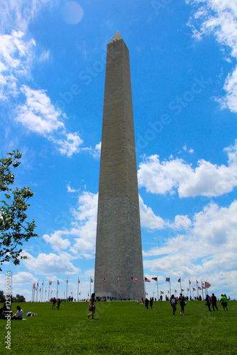 Visitors explore the Washington Monument under a bright blue sky