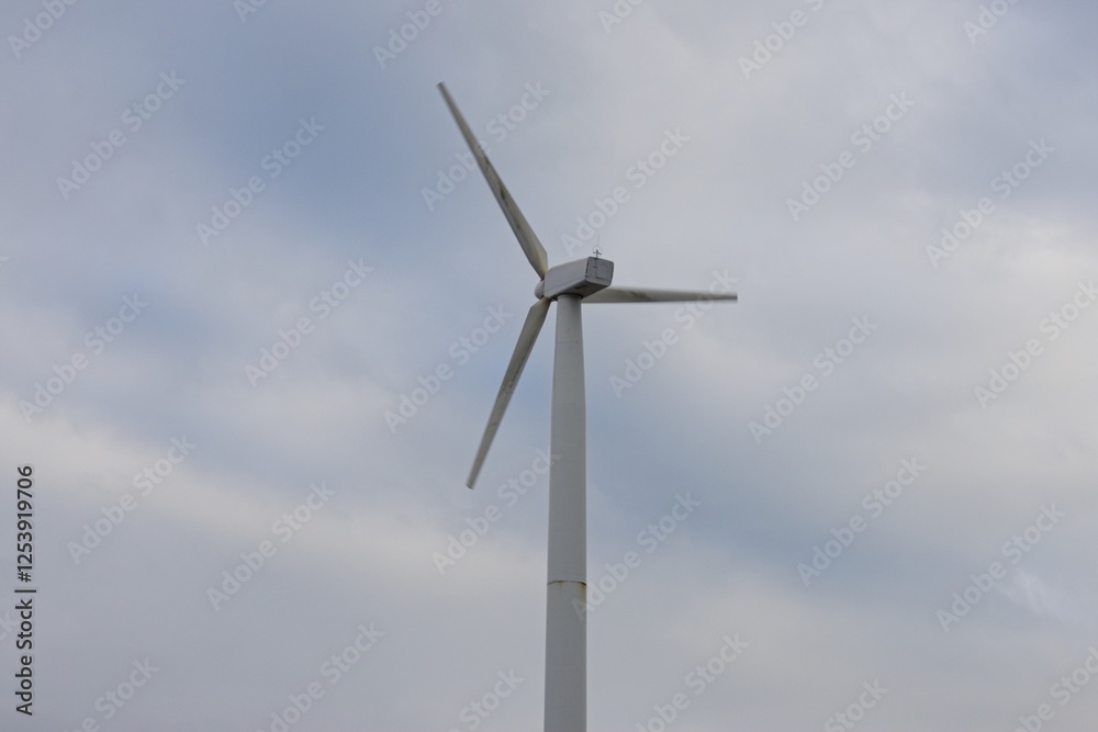 a wind turbine with three blades against a cloudy sky. Wind turbines generate renewable energy by converting wind power into electricity, essential for sustainable energy solutions. a wind turbine with three blades against a cloudy sky. Wind turbines generate renewable energy by converting wind power into electricity, essential for sustainable energy solutions.