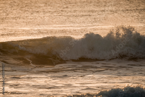 Fototapeta Naklejka Na Ścianę i Meble -  beautiful wave during sunset golden hour orange pretty ocean sea 