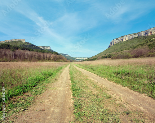 Spring Crimean mountain landscape and rural roads in valley (Mangup Kale - historic fortress and ancient cave settlement in Crimea, Ukraine)